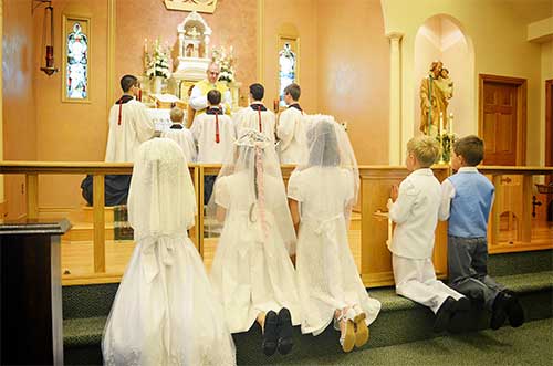 Chapel Mass with kneeling worshippers – About Us